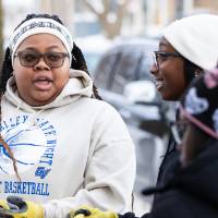 students stand outside, wearing work gloves